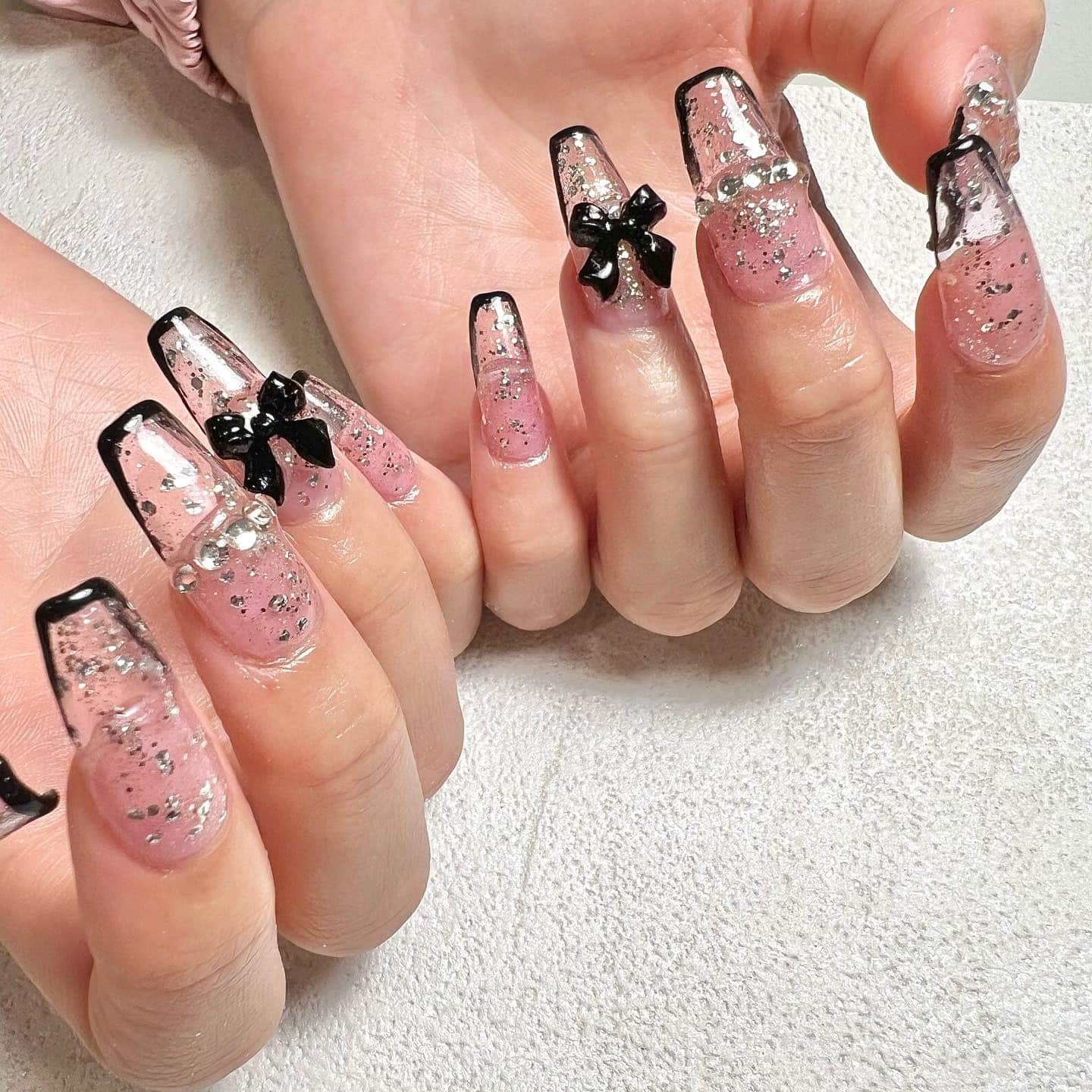 14. Pink Glitter Coffin Nails with Black Bow Accents - medium length coffin nail ideas