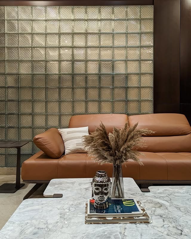 3. Textured Wall Contrast with Low-Profile Leather Seating - brown leather sofa living room ideas