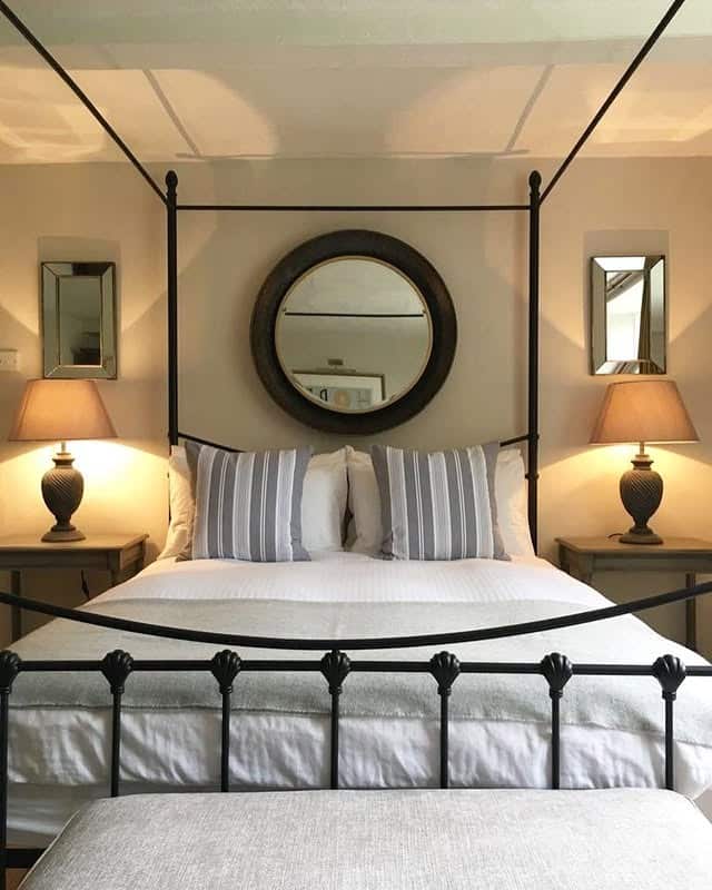 4. Classic Black Canopy with Neutral Layers - metal bed frame bedroom ideas