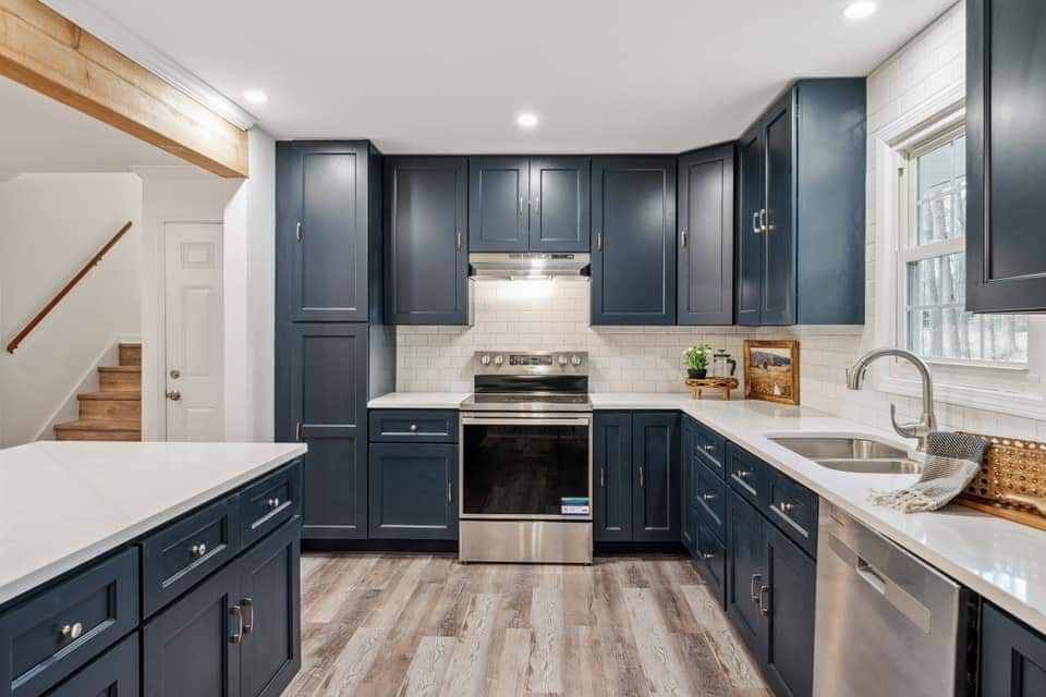 7. Modern Blue Kitchen with Brass Hardware Details - gray and blue kitchen ideas