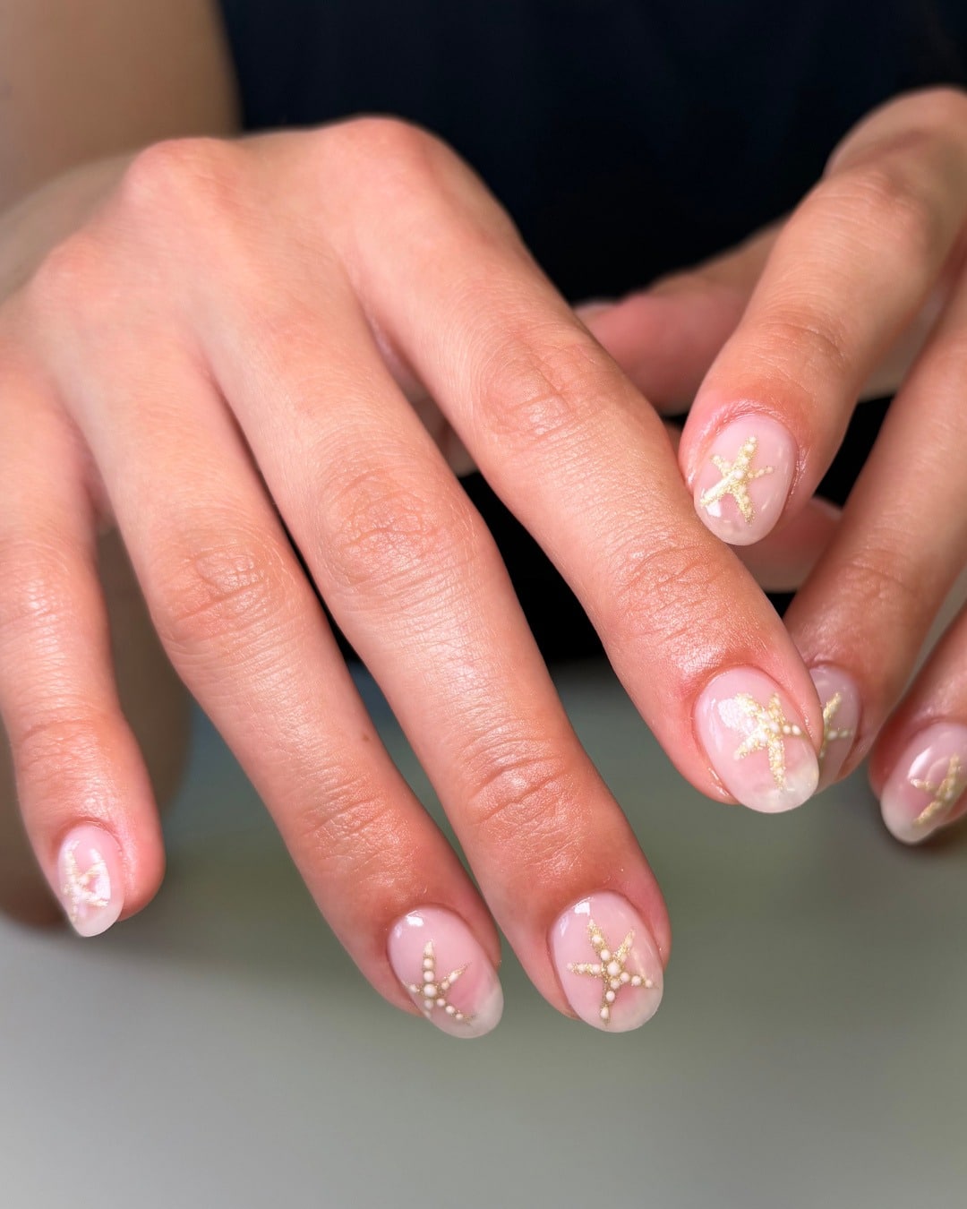 10. Subtle Starfish Accent Nails in Soft Nude and Gold - nautical nail ideas