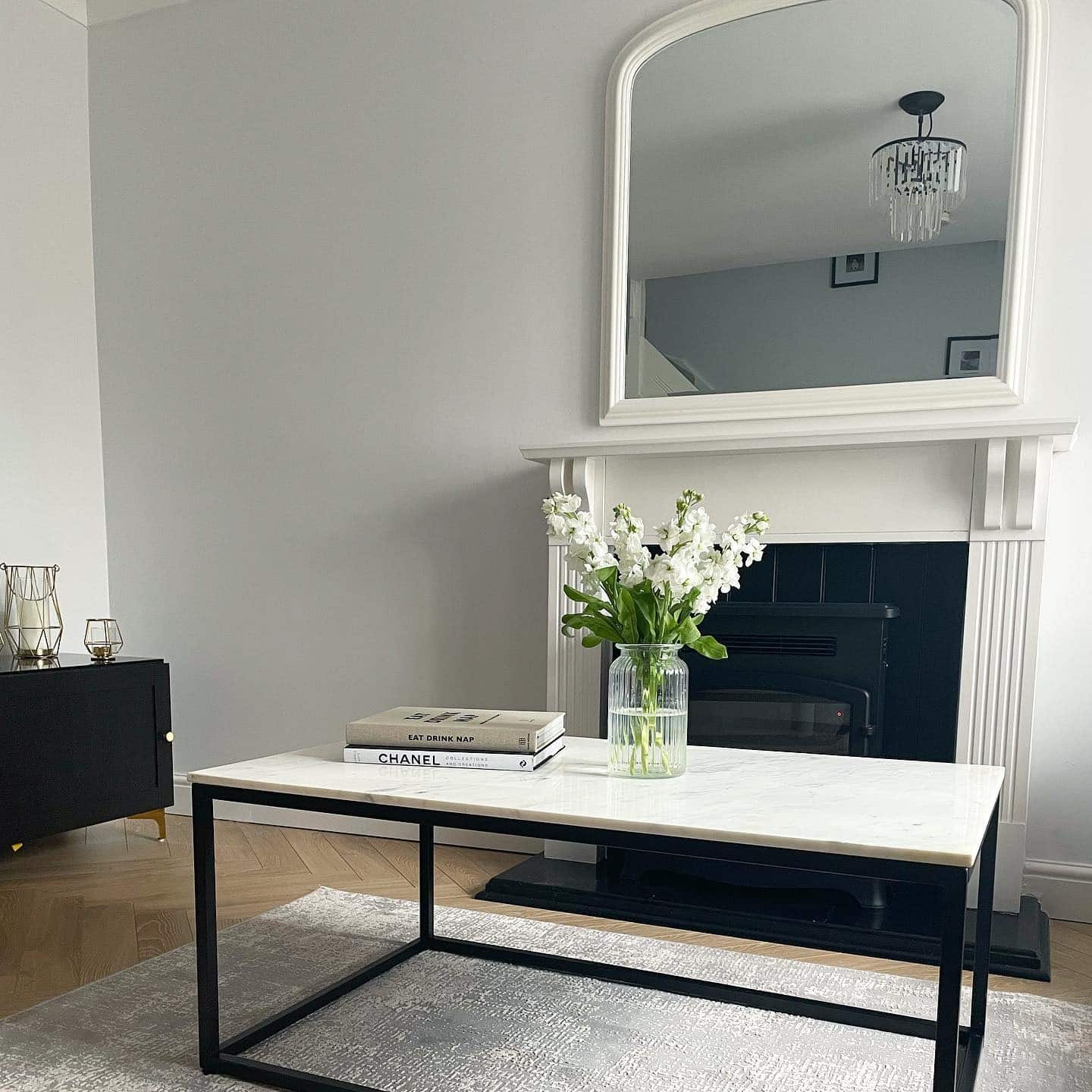 5. Minimal Fireplace Mirror with Black and White Contrast - living room mirror ideas