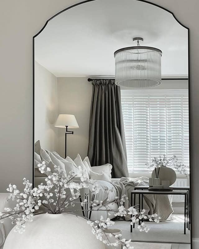 8. Statement Arched Mirror with Layered Neutral Decor - living room mirror ideas
