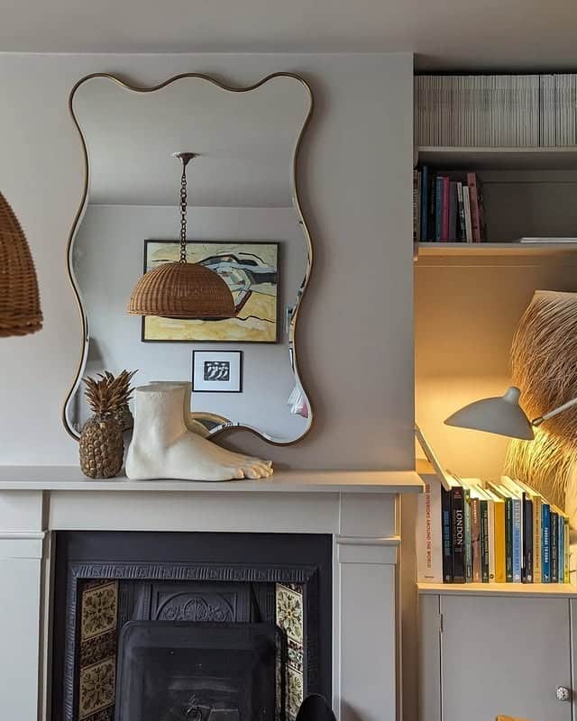 11. Sculptural Fireplace Mirror in Warm Neutrals - living room mirror ideas