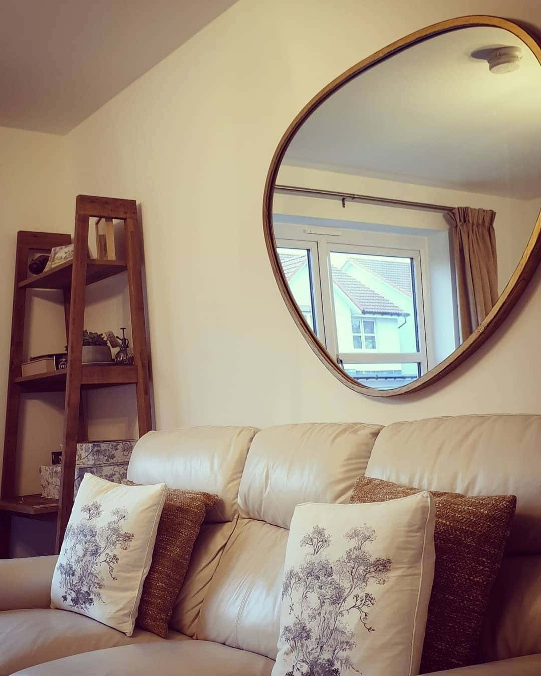 12. Round Wall Mirror with Cream and Wood Tones - living room mirror ideas