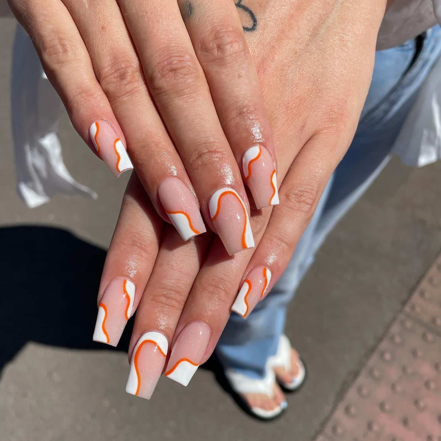 5. Abstract Orange French Tips on Glossy Nude Base - orange and white nail ideas