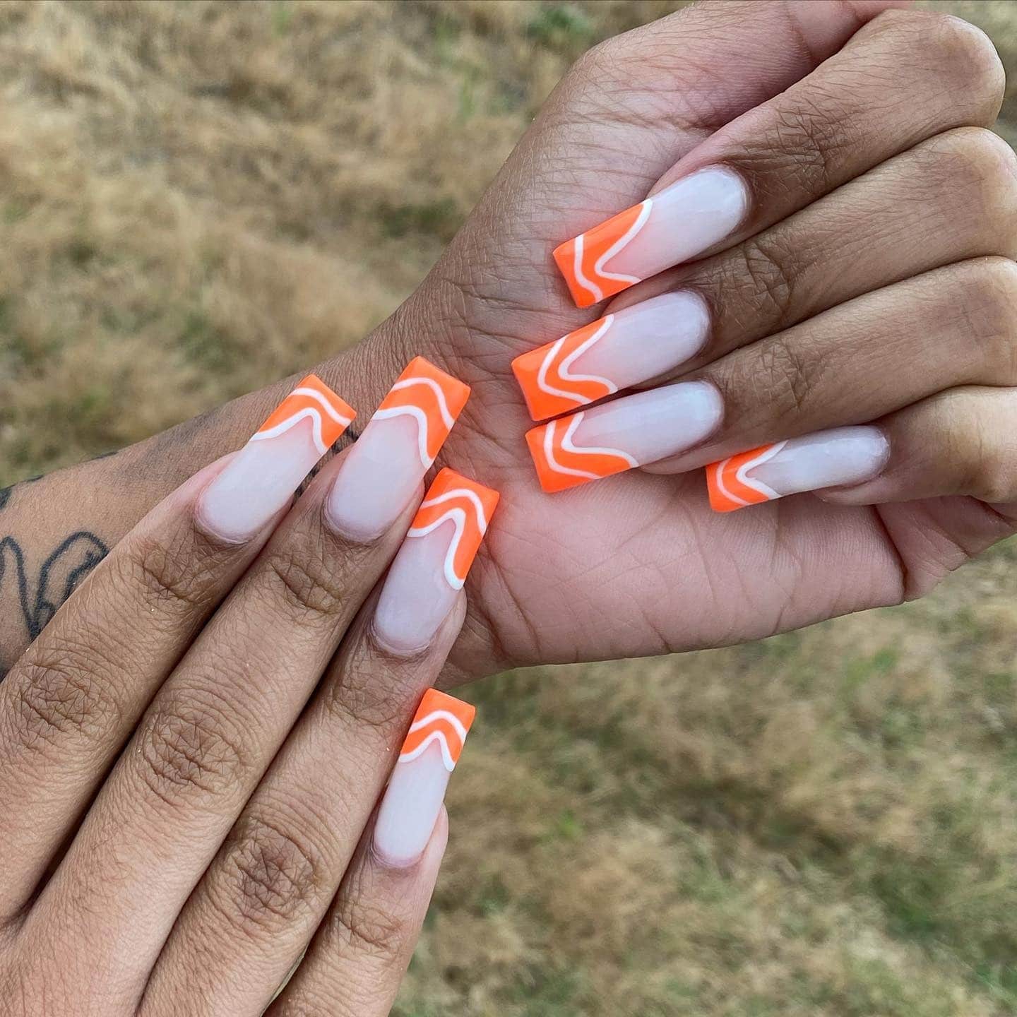 10. Neon Orange Swirl Tips on Nude Coffin Nails - orange and white nail ideas