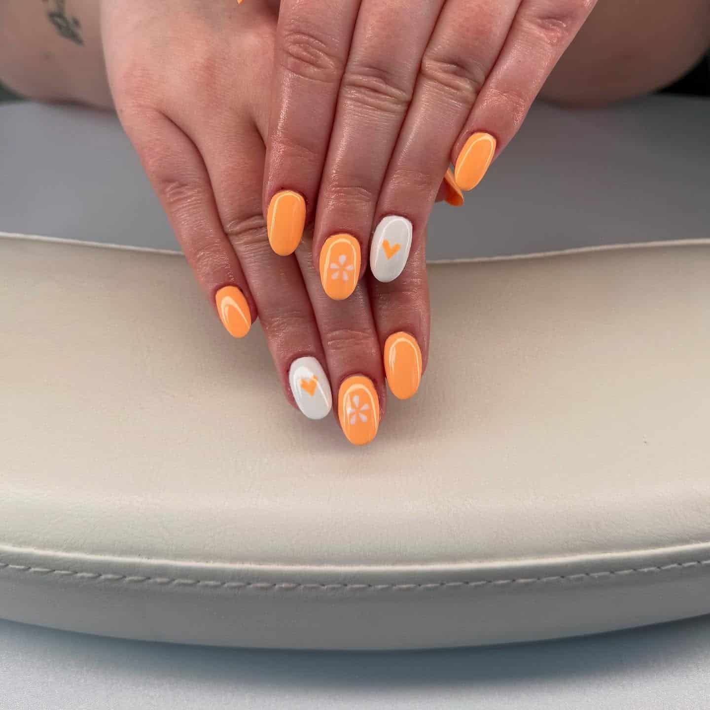 13. Solid Orange Oval Nails with White Floral Accents - orange and white nail ideas