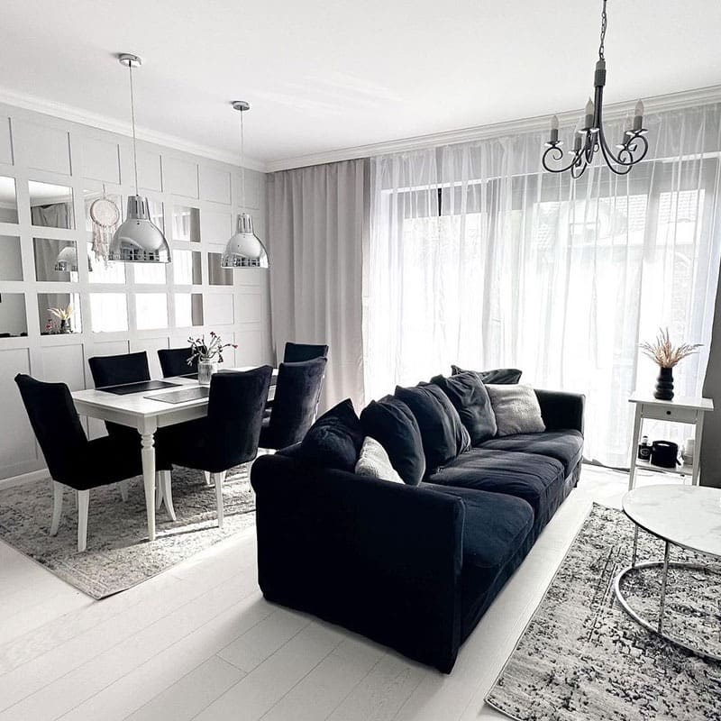 3. Black and White Open-Plan Living Space with Soft Gray Layers - black furniture living room ideas