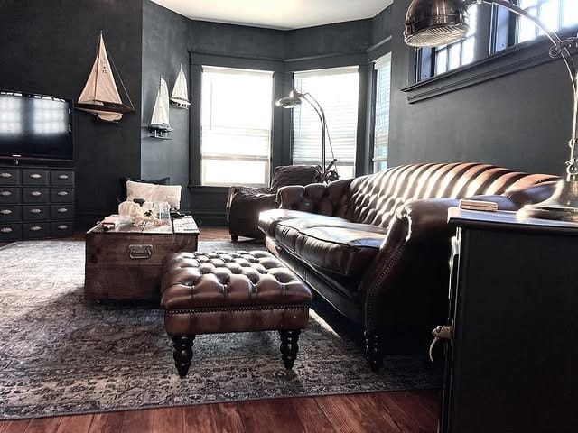 6. Moody Grey Living Room with Traditional Fireplace - dark grey living room ideas