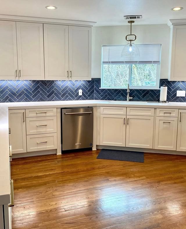 2. Classic White Cabinetry with Deep Blue Herringbone Backsplash - blue backsplash kitchen ideas