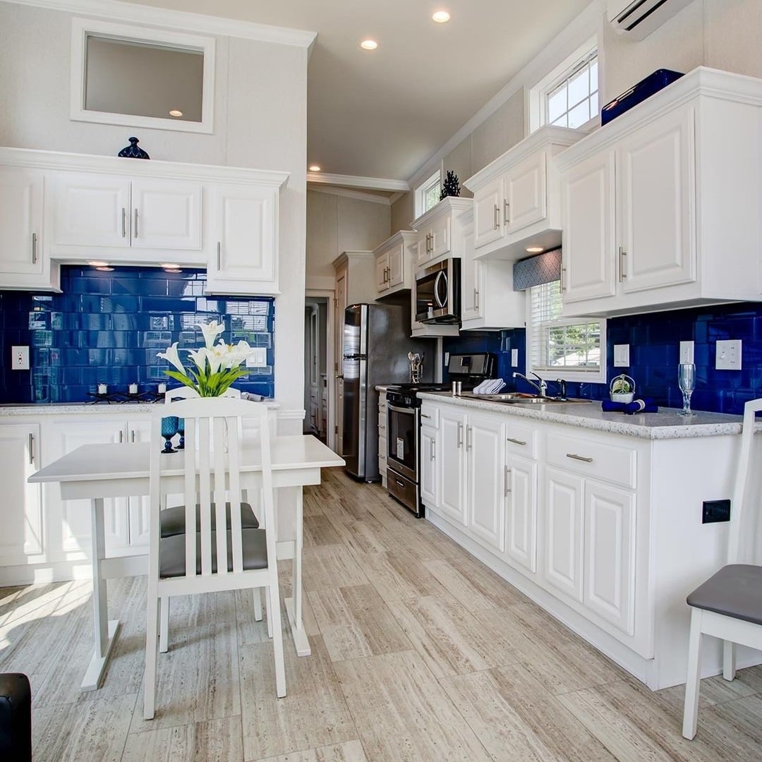 8. Bright White Kitchen with Rich Blue Ceramic Backsplash - blue backsplash kitchen ideas