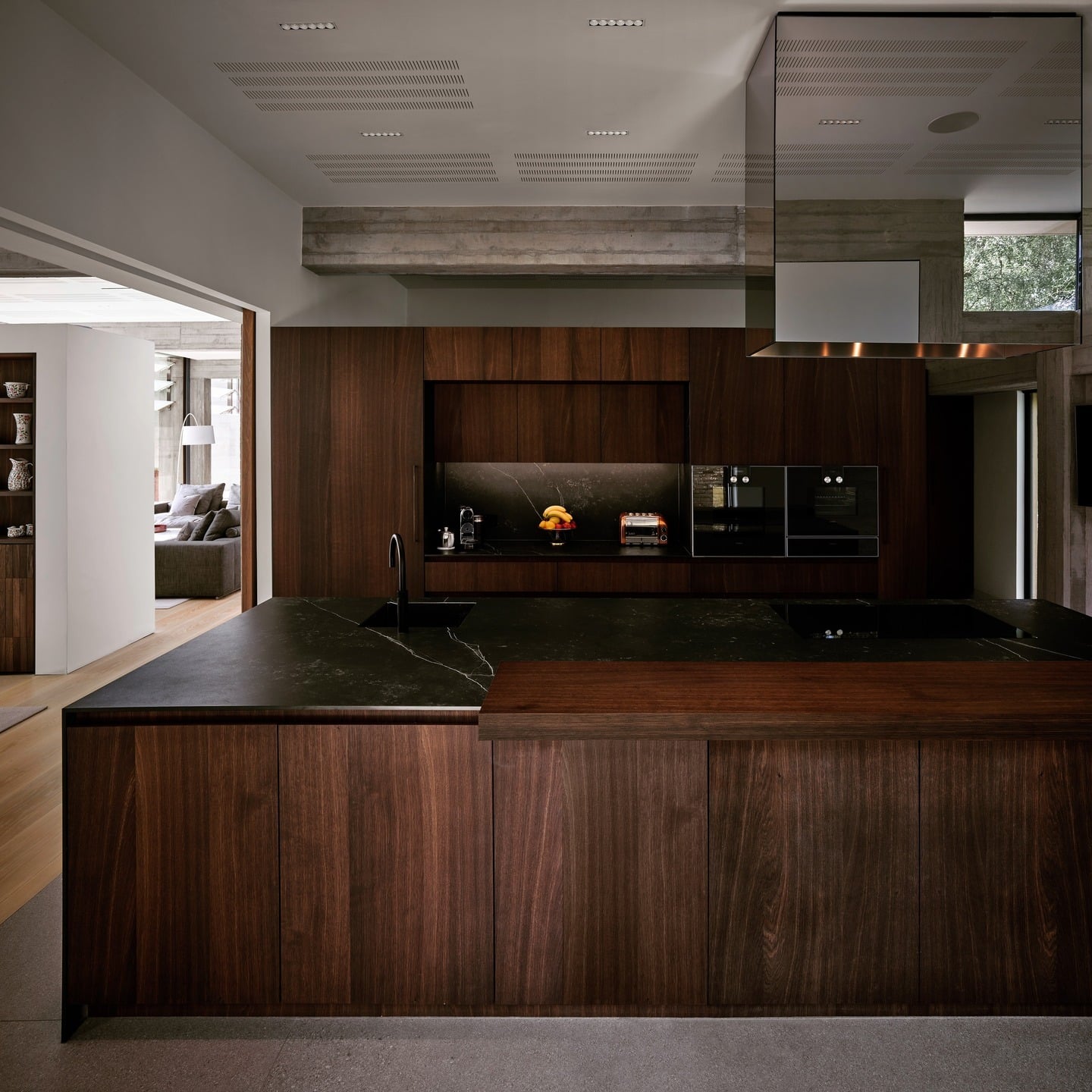 3. Architectural Dark Wood Kitchen with Black Stone Island - dark wood kitchen ideas