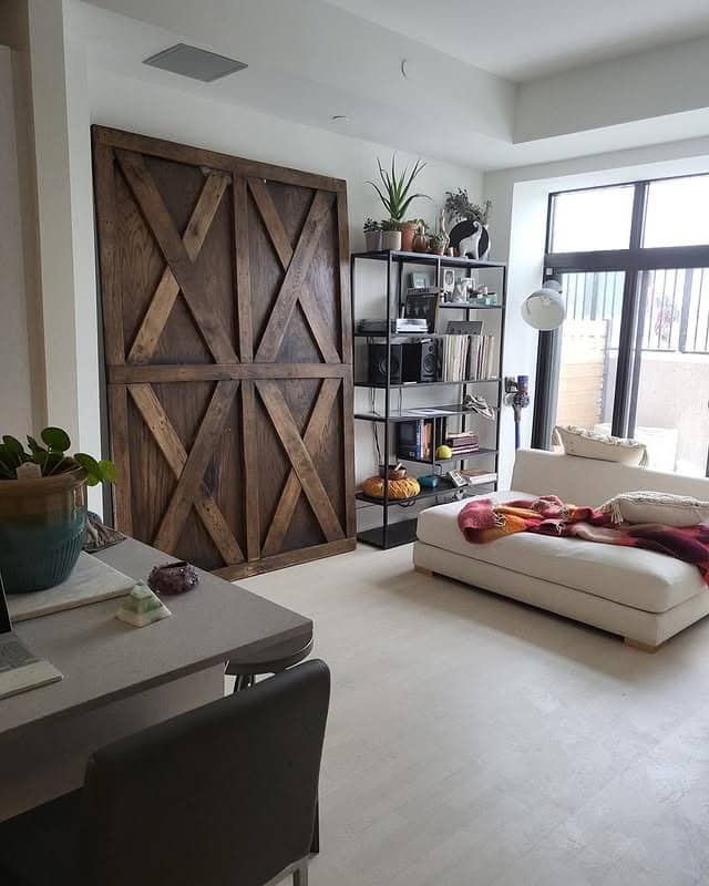 2. Rustic Wood Barn Door Accent Wall in Neutral Living Space - accent wall ideas for living room