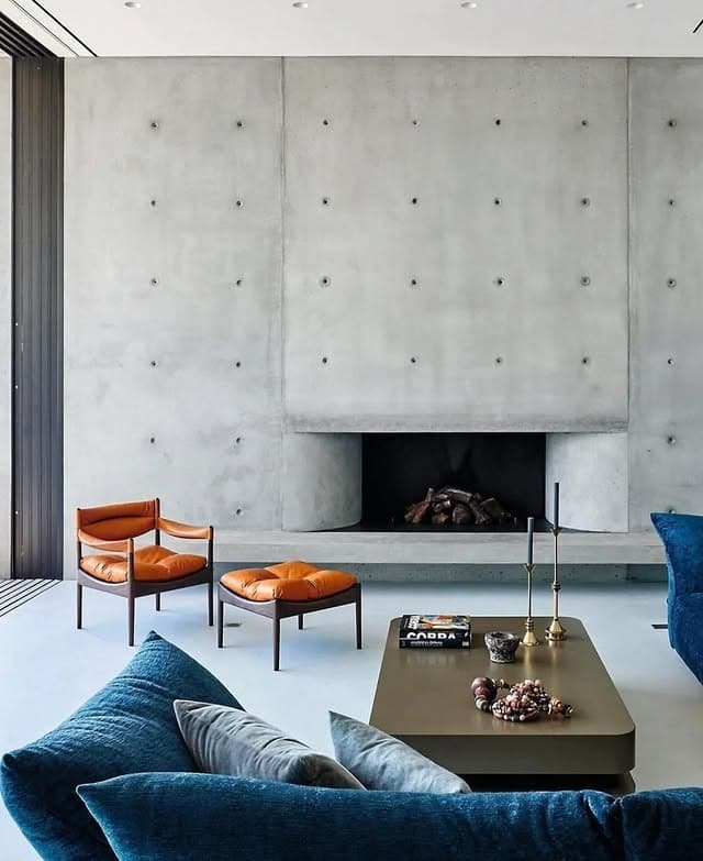 3. Concrete Gray Fireplace Accent Wall with Warm Leather Accents - accent wall ideas for living room