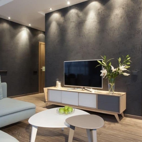 5. Textured Graphite Accent Wall with Modern Lighting - accent wall ideas for living room