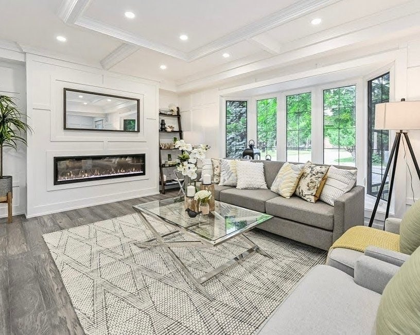 9. Crisp White Paneled Accent Wall with Linear Fireplace - accent wall ideas for living room