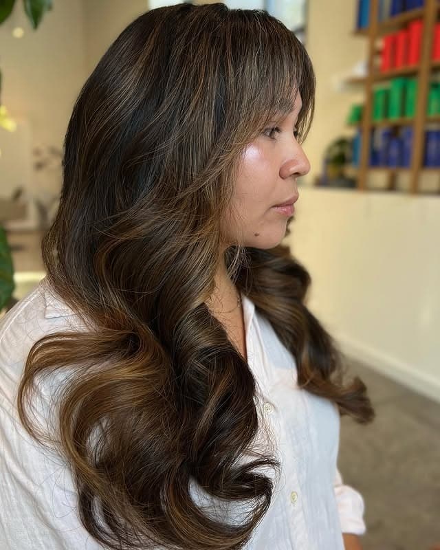 5. Long Cascading Layers with Wispy Bangs in Brunette Balayage - Long Layered Hairstyles with Bangs