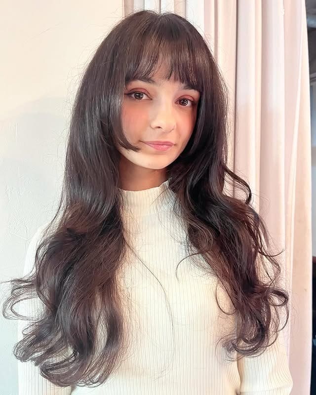 7. Long Layered Cut with Rounded Bangs in Cool Black - Long Layered Hairstyles with Bangs