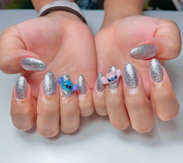 11. Silver Glitter Almond Nails with Character Accents - silver glitter nail ideas
