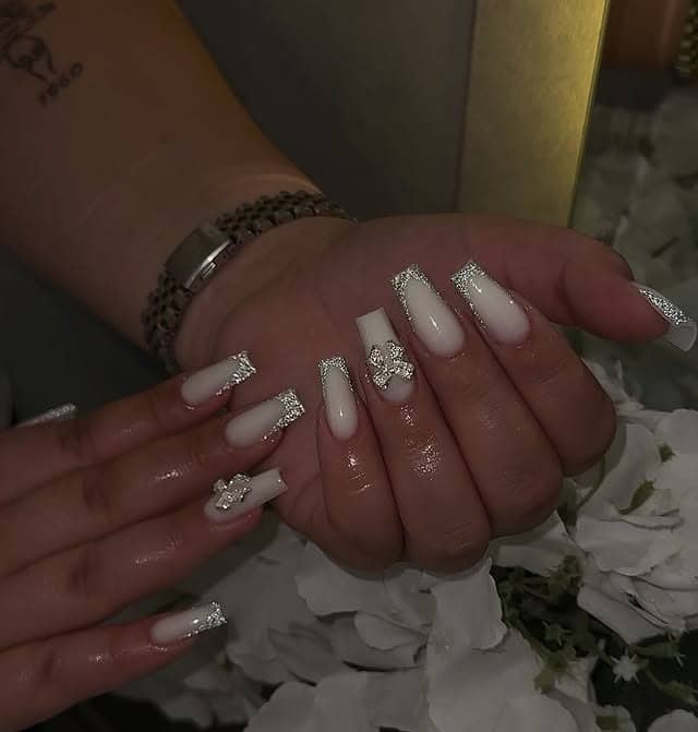 19. White Coffin Nails with Silver Glitter Tips and Charms - silver glitter nail ideas