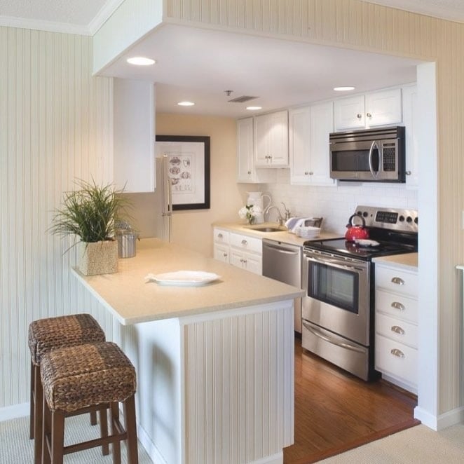 12. Compact White Kitchen with Light Wood Breakfast Bar - small cozy kitchen ideas