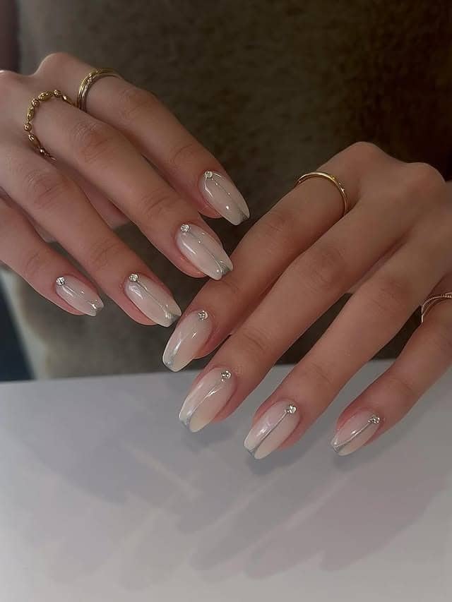 16. Almond Milky Nude Nails with Silver Stud Line Details - simple line nail ideas