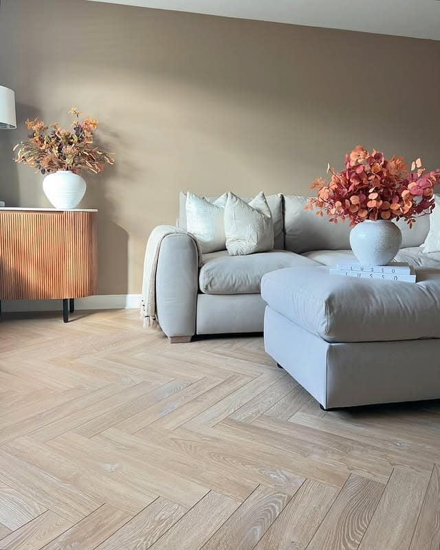 21. Soft Oak Herringbone Flooring with Warm Neutral Styling - living room floor ideas