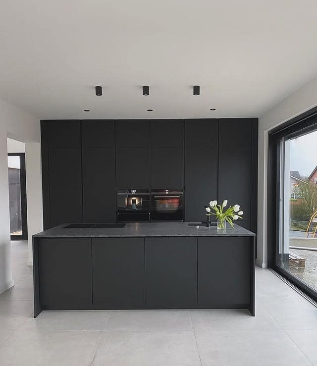 17. Modern Black Kitchen with Central Island Focus - black kitchen ideas