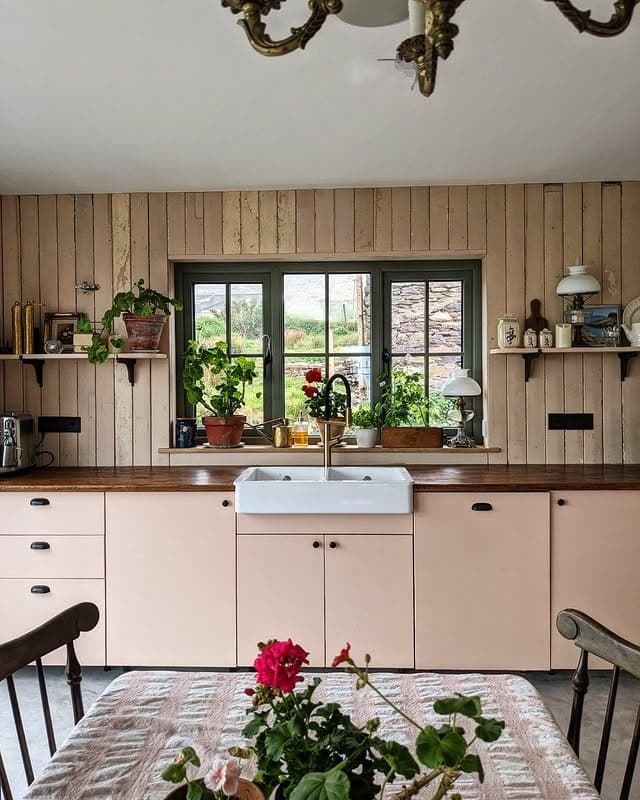 4. Cottage-Inspired Kitchen with Blush Cabinetry - kitchen window ideas