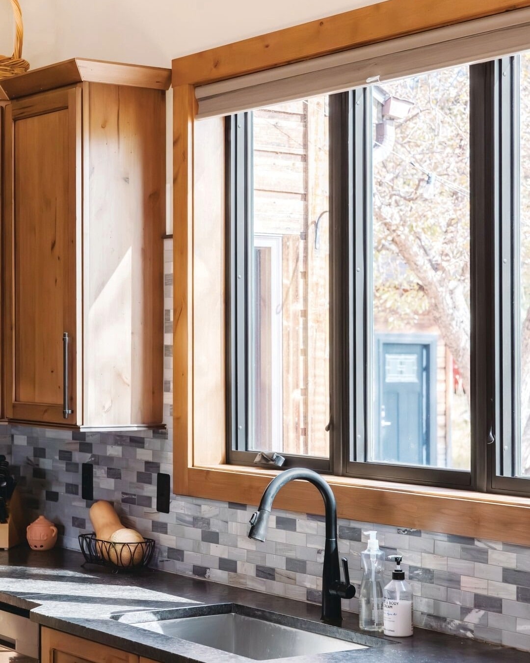 22. Natural Wood Kitchen with Black-Framed Sliding Window - kitchen window ideas