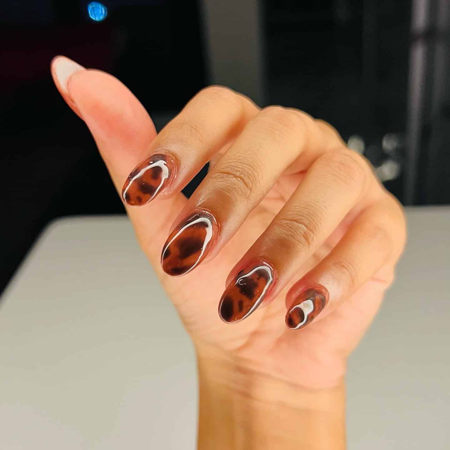 4. Almond Tortoiseshell Nails with White Outline Accents - turtle nail ideas