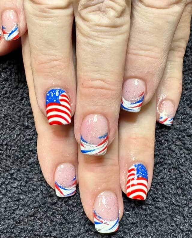 22. Short Glitter Nude Nails with Curved Flag Art - us flag nail ideas