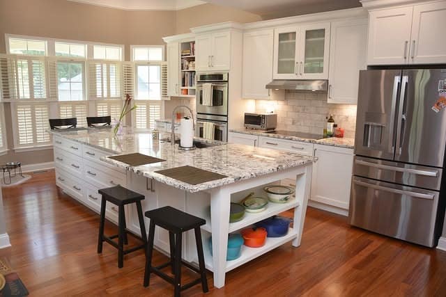 12. Bright White Granite Island with Warm Wood Floors - granite countertops kitchen ideas