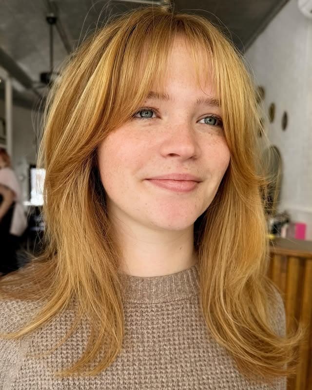 12. Long Layered Cut with Feathered Bangs in Golden Strawberry Blonde - Short Layered Haircuts with Bangs