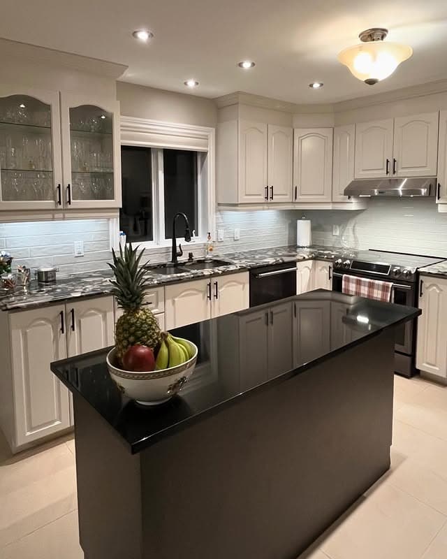 6. Elegant Cream Kitchen with Oak Island and Black Accents - oak cabinets kitchen ideas