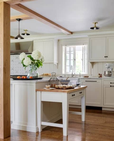 7. Elegant Farmhouse Kitchen with Cream Cabinets and Wood Beams - farmhouse kitchen ideas