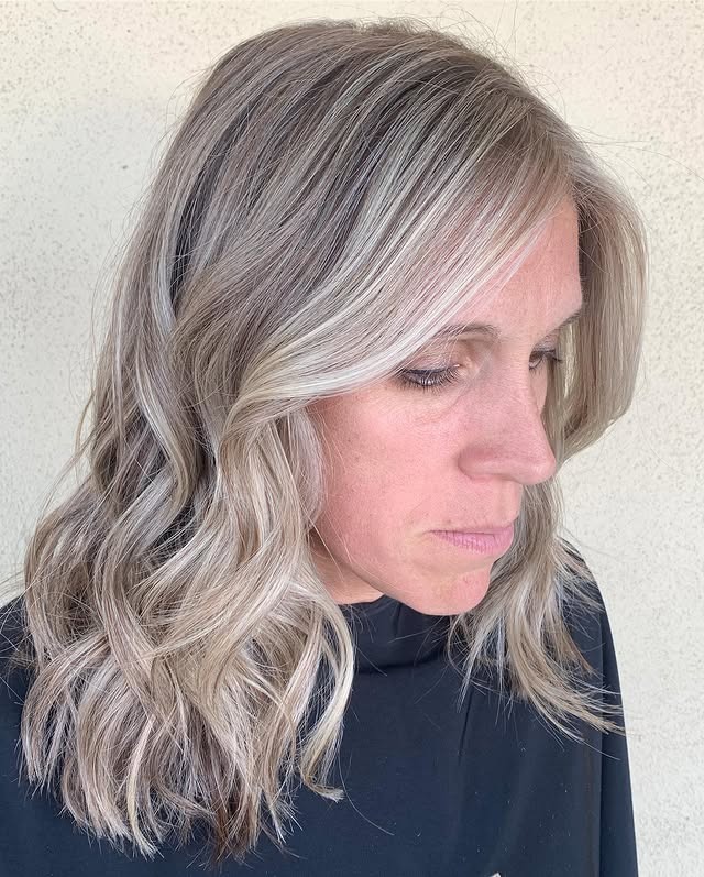 7. Dimensional Silver Blonde with Loose Waves - Medium-Length Hairstyles