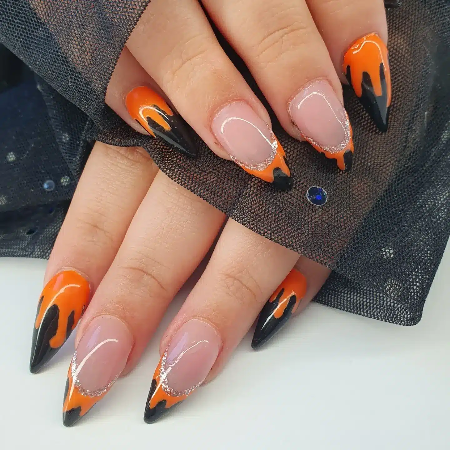 8. Black and Orange Drip French Nails with Glitter Detail - black and orange nail ideas