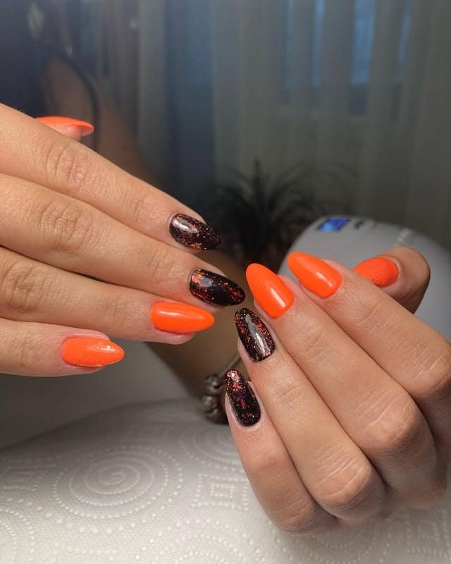 14. Black Glitter and Orange Almond Nails - black and orange nail ideas