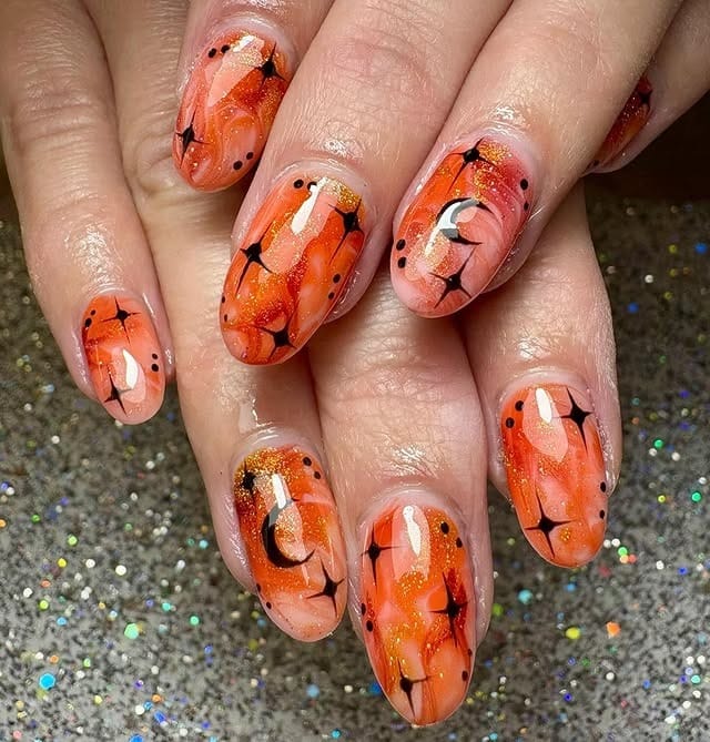 22. Black and Orange Shimmer Almond Nails with Celestial Art - black and orange nail ideas