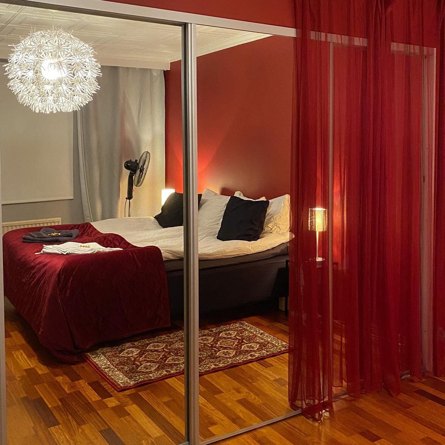 5. Red Elegance with Mirrored Depth - red bedroom ideas