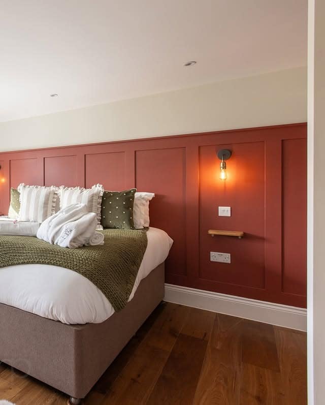 11. Tailored Red Panel Bedroom with Warm Neutrals - red bedroom ideas