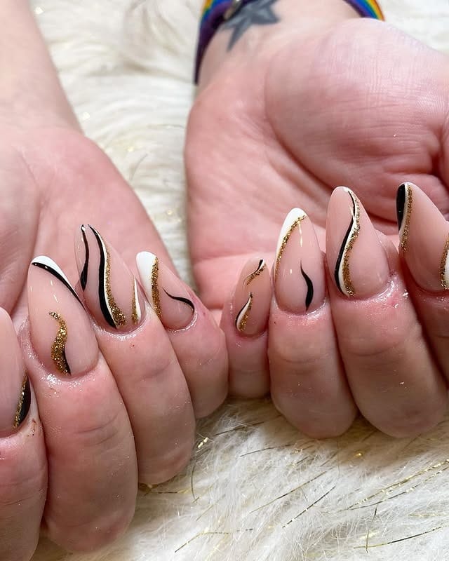 7. Nude Base with Flowing Black and Gold Lines - black, white and gold nail ideas