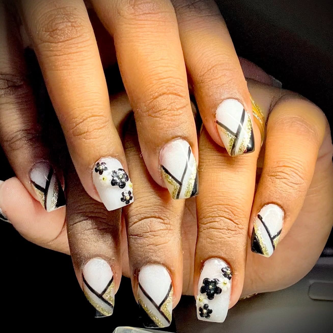9. White Nails with Black Striping and Gold Floral Accents - black, white and gold nail ideas