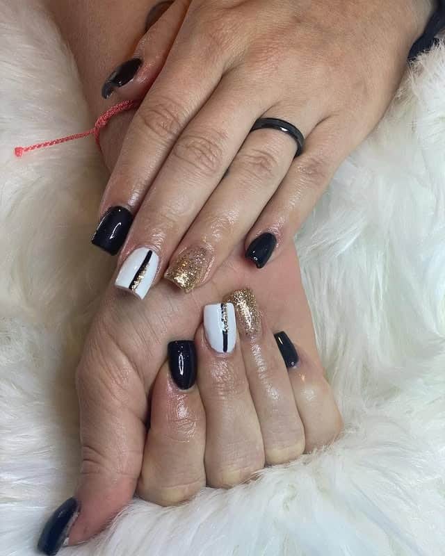 11. Classic Black and White with Gold Stripe Accent - black, white and gold nail ideas