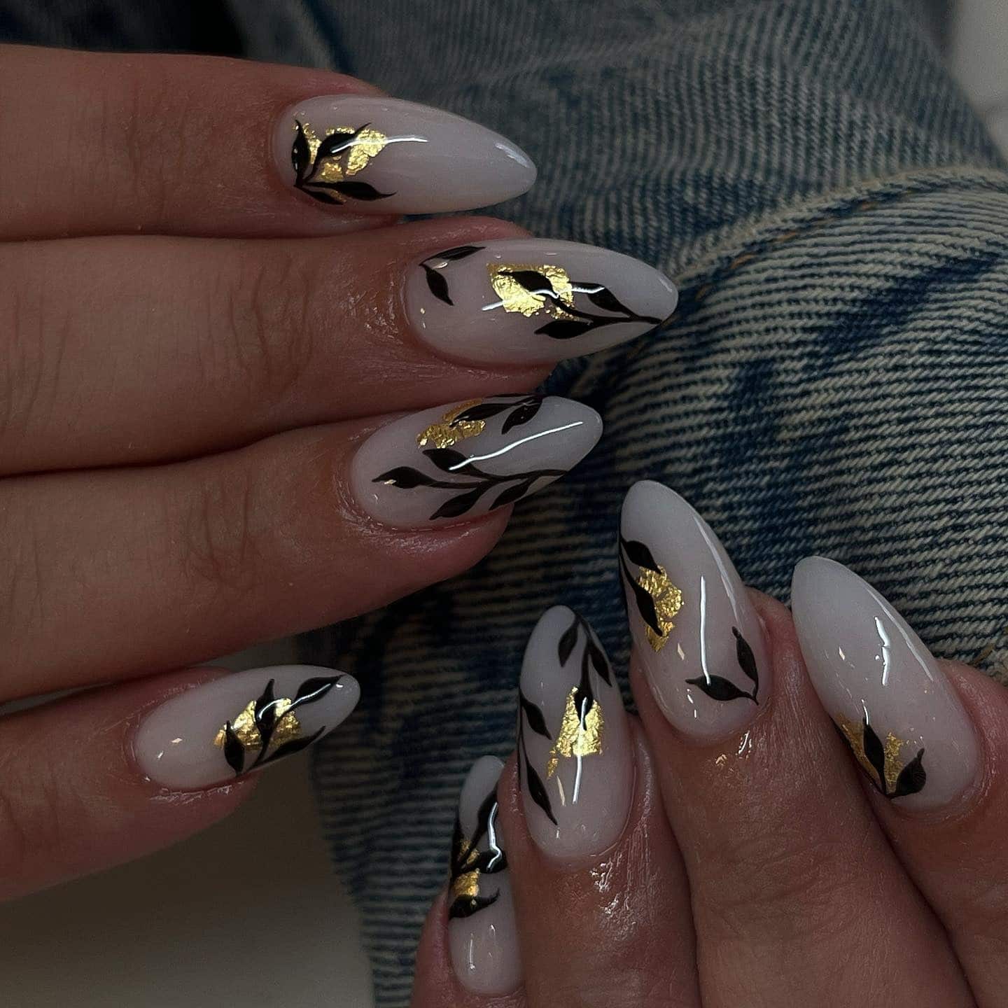 21. Almond Nude Nails with Black Botanical Art and Gold Foil - black, white and gold nail ideas