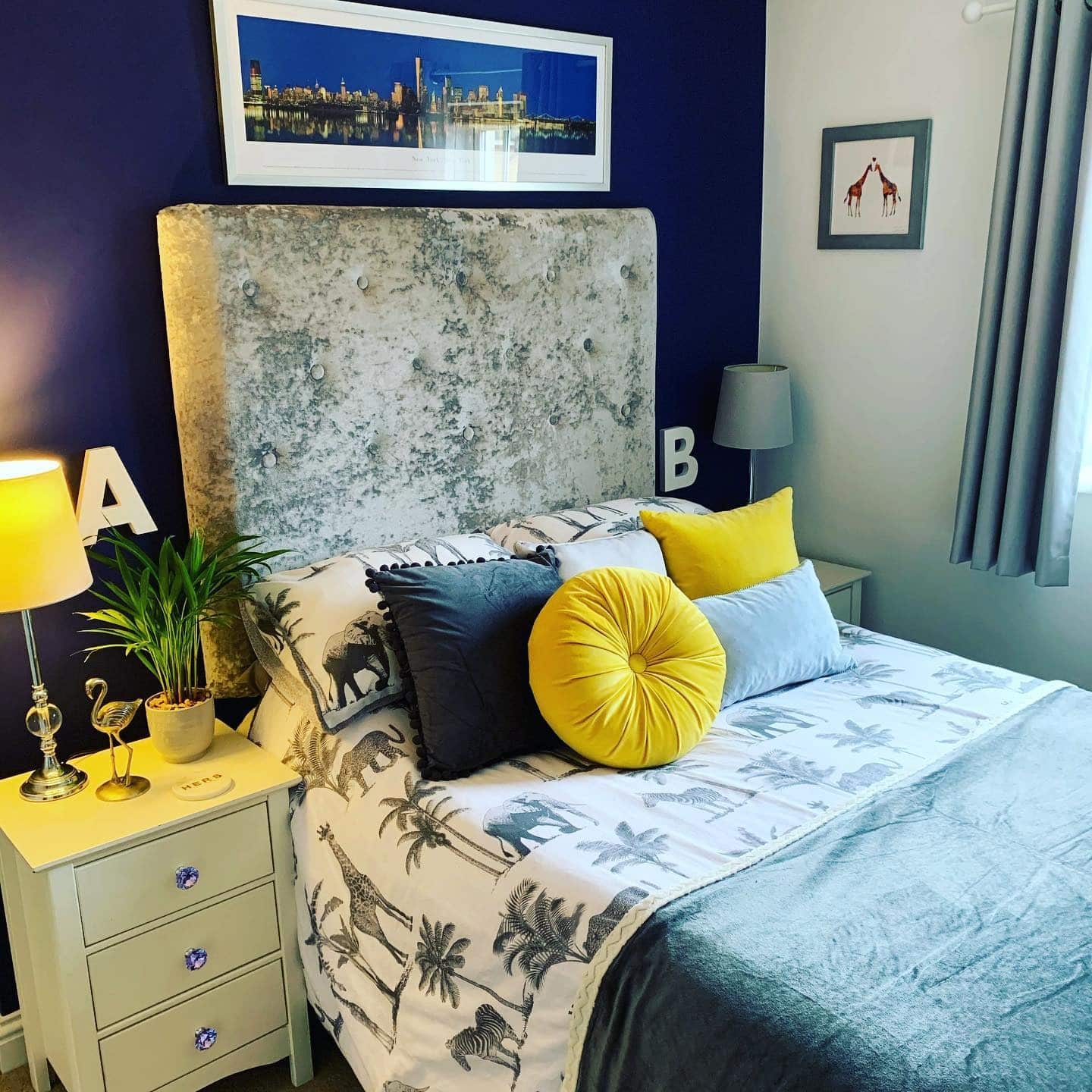 15. Deep Blue Feature Wall with Yellow Accent Cushions - yellow and blue bedroom ideas