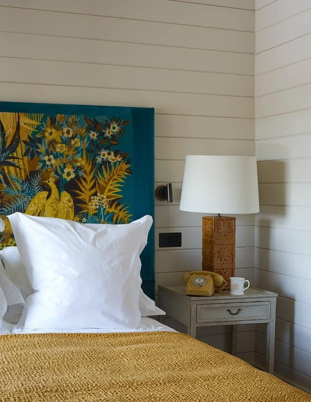 21. Blue Upholstered Headboard with Mustard Textile Accents - yellow and blue bedroom ideas