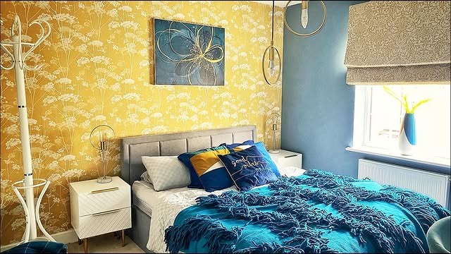 22. Yellow Botanical Wallpaper with Layered Blue Bedding - yellow and blue bedroom ideas